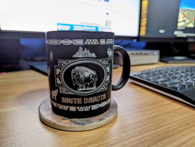 Coffee Cup on desk. South Dakota is written on the coffee cup.